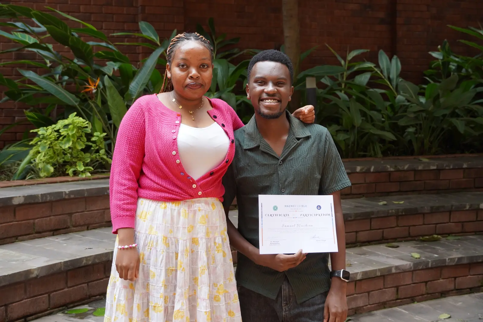 Two Hackcessible participants celebrating with a certificate of participation at Aga Khan University